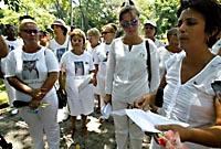 ALEJANDRA GARCIA (derecha), lee una carta en una alto de la caminata por el paseo central de la Quinta Avenida, en La Habana.